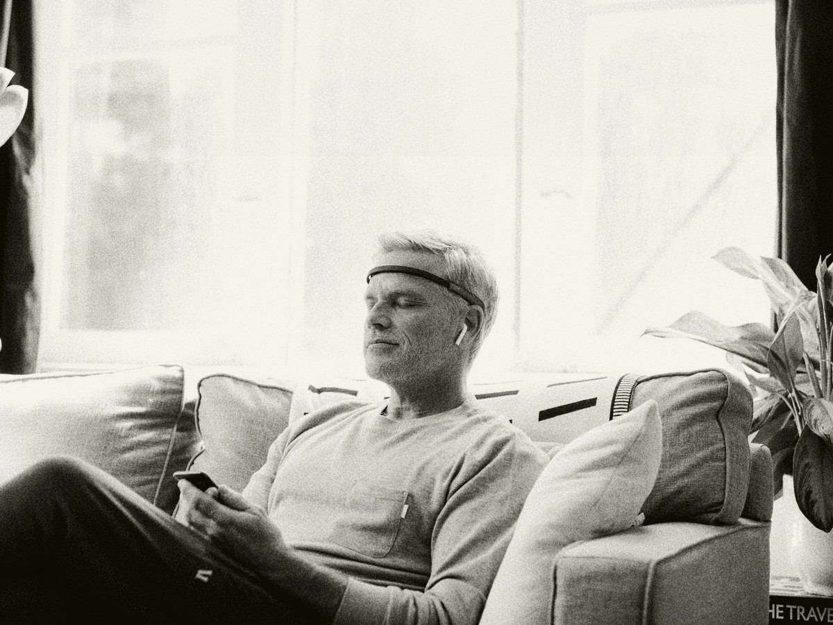 Persona usando una banda Muse en un sillón, fotografía en blanco y negro